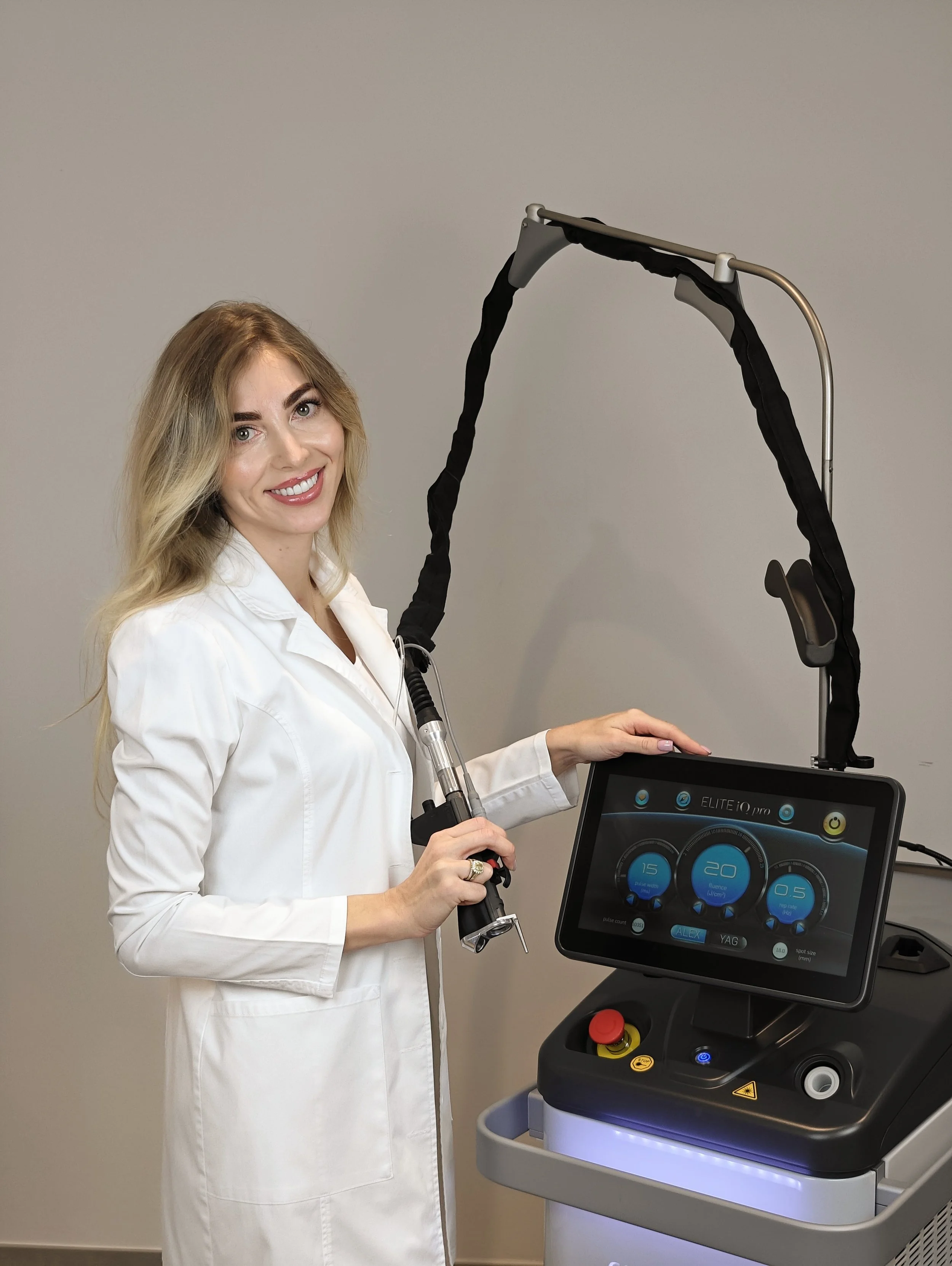 Mulher a operar um equipamento de laser médico com controlos táteis.